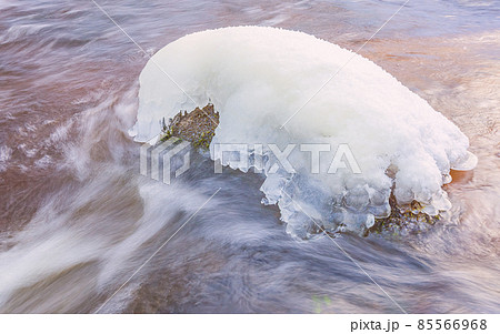 Icicles over the water in the river. Natural landscape. Winter. Background image. Icicles over the water in the river. Natural landscape. Winter. Background image. 85566968