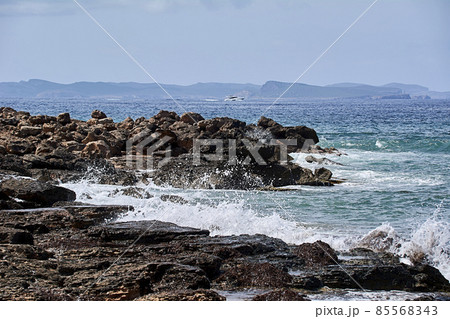 Rocks on the shore hit by the wave 85568343