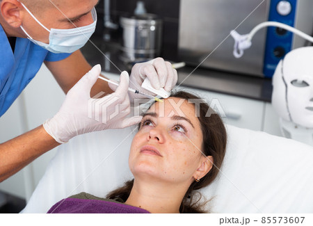 Female client during procedure of face mesotherapy in aesthetic cosmetology clinic Female client during procedure of face mesotherapy in aesthetic cosmetology clinic 85573607