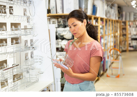 Woman choosing chrome bathroom coasters at hardware store Woman choosing chrome bathroom coasters at hardware store 85573608