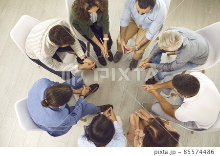 Overhead view of young and mature patients meeting for conversation with psychologist or psychotherapist. High angle shot of group of people sitting in circle during therapy session with psychiatrist Overhead view of young and mature patients meeting for conversation with psychologist or psychotherapist. High angle shot of group of people sitting in circle during therapy session with psychiatrist 85574486