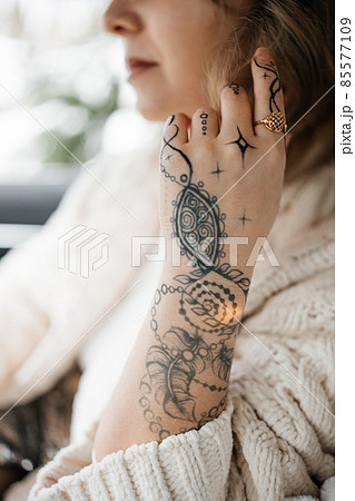 Unrecognisable young lady with painted hand sacral mehendi 85577109