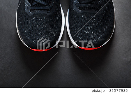 Black running shoes with mesh and black laces close-up on a dark background Black running shoes with mesh and black laces close-up on a dark background 85577986