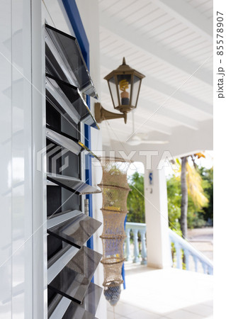 Windows from dark glass blinds. Windows in the tropics with glass blinds and mosquitos net. Selective focus. Windows from dark glass blinds. Windows in the tropics with glass blinds and mosquitos net. Selective focus. 85578907