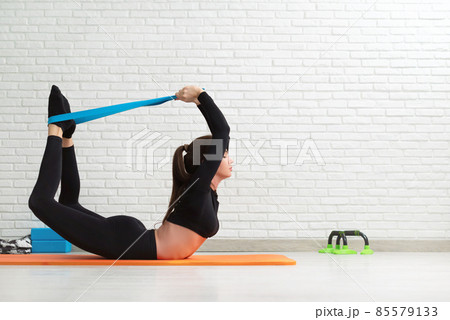 the girl conducts a home workout stretching to strengthen her back the girl conducts a home workout stretching to strengthen her back 85579133