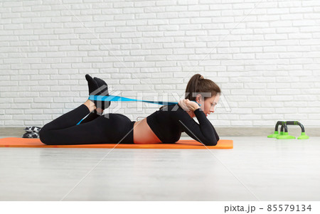 the girl conducts a home workout stretching to strengthen her back 85579134
