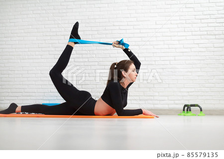 the girl conducts a home workout stretching to strengthen her back the girl conducts a home workout stretching to strengthen her back 85579135