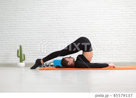 the girl conducts a home workout stretching to strengthen her back the girl conducts a home workout stretching to strengthen her back 85579137