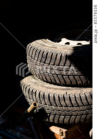 Two car wheels lying in a dark garage 85579336