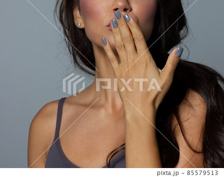 Beauty closeup of brunette lower face with clean skin and evening makeup. The girl looks at the camera and sends an air kiss. Smooth eyebrows and very long eyelashes 85579513