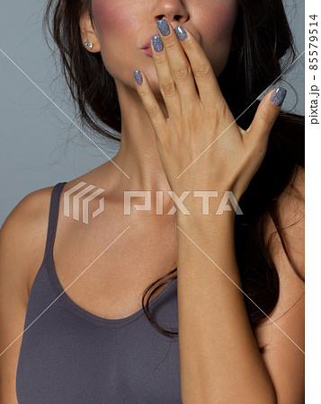 Beauty closeup of brunette lower face with clean skin and evening makeup. The girl looks at the camera and sends an air kiss. Smooth eyebrows and very long eyelashes 85579514