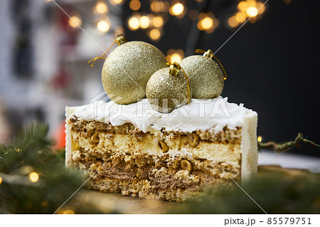 A slice of a cake on a background of christmas lights. 85579751