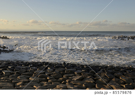 夕方の波が打ち寄せる海岸 85579876