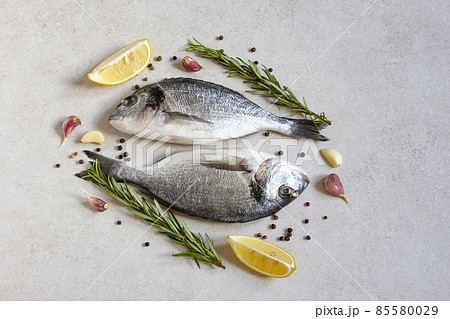 Two fresh raw sea organic dorado or sea bream with spices and lemon 85580029