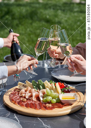 Snack for guests. A plate of cheese, salami, nuts, grapes and snacks on a tray. 85580064