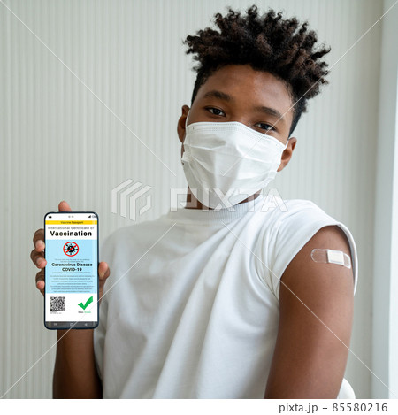 African American teenager shows vaccine passport on mobile phone African American teenager shows vaccine passport on mobile phone 85580216