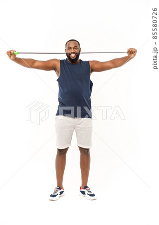 African fitness model with skipping rope against grey background. Handsome muscular man posing with jumping rope. 85580726