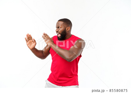 Portrait of young muscular african american male boxer looking aside, punching, standing isolated over grey background. Sport, workout, bodybuilding. 85580875