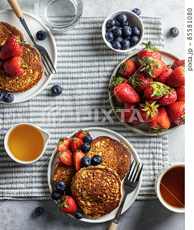 Pancakes with berries on a striped breakfast tablecloth. Top view 85581080