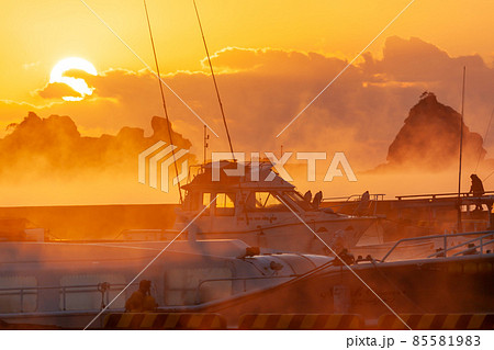 太平洋日向灘に昇る日出で黄昏色に染まった日南海岸の南郷町外ノ浦港に立ち昇る毛嵐 85581983