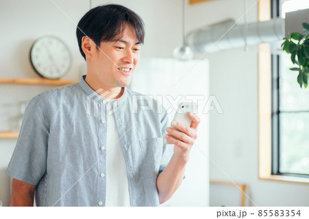 家でスマホを使う男性（アプリ） 85583354