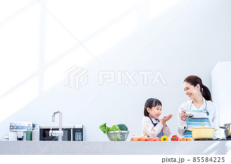 ママと一緒に料理をする小学生 光の入るキッチン ママと一緒に料理をする小学生 光の入るキッチン 85584225