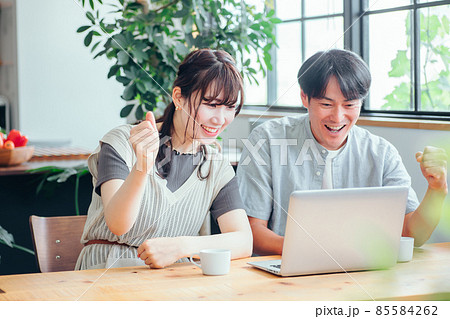ノートパソコンを見る男女（応援） 85584262