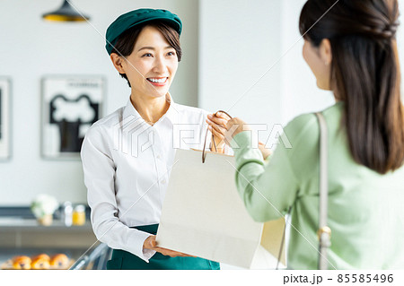 商品を渡すミドルの店員 商品を渡すミドルの店員 85585496
