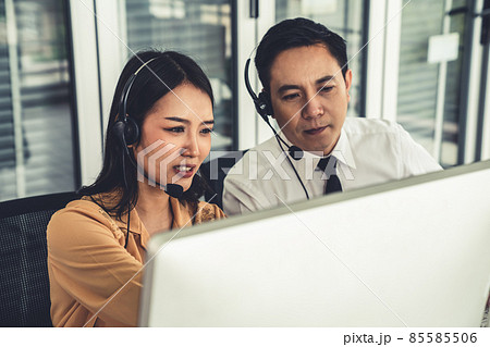 Business people wearing headset working actively in office Business people wearing headset working actively in office 85585506