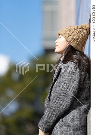 ビルの壁にもたれて立っている女性 ビルの壁にもたれて立っている女性 85585565