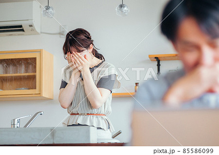 辛い思いをする女性とパソコンを使う男性 辛い思いをする女性とパソコンを使う男性 85586099