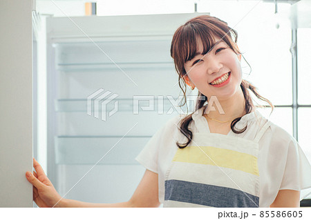 何も入ってない冷蔵庫を見る女性(カメラ目線) 何も入ってない冷蔵庫を見る女性(カメラ目線) 85586605
