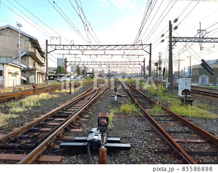 踏切から伸びる線路の先に見える駅 85586898