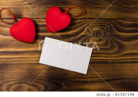 Valentine's day blank greeting card and two red hearts on wooden background 85587196