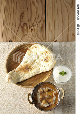 鶏肉や落花生など沢山の具材が入っている熱々マッサマンカレーとナンとラッシ― 鶏肉や落花生など沢山の具材が入っている熱々マッサマンカレーとナンとラッシ― 85588386