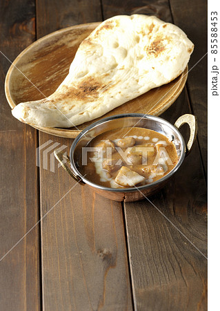 鶏肉や落花生など沢山の具材が入っている熱々マッサマンカレーとナン 85588453