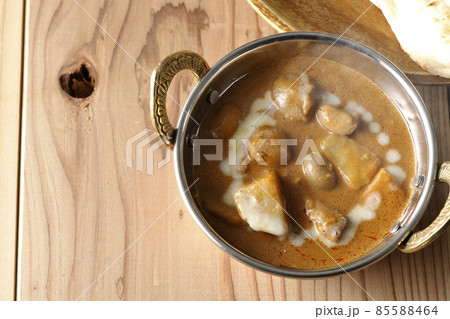 鶏肉や落花生など沢山の具材が入っている熱々マッサマンカレーとナンを俯瞰で撮影 85588464