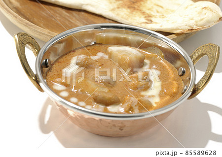 鶏肉や落花生など沢山の具材が入っている熱々マッサマンカレーとナンを白背景で撮影 85589628