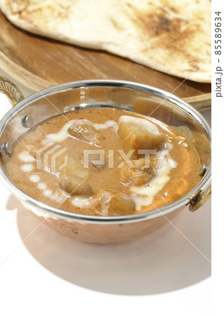 鶏肉や落花生など沢山の具材が入っている熱々マッサマンカレーとナンを白背景で撮影 85589634