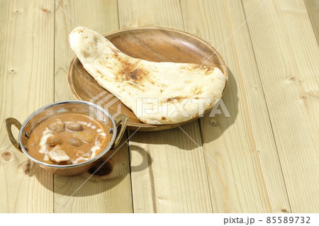 鶏肉や落花生など沢山の具材が入っている熱々マッサマンカレーとナン 85589732