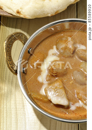 鶏肉や落花生など沢山の具材が入っている熱々マッサマンカレーとナンを俯瞰で撮影 85589910