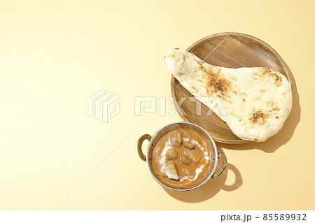 鶏肉や落花生など沢山の具材が入っている熱々マッサマンカレーとナンを俯瞰で撮影 85589932