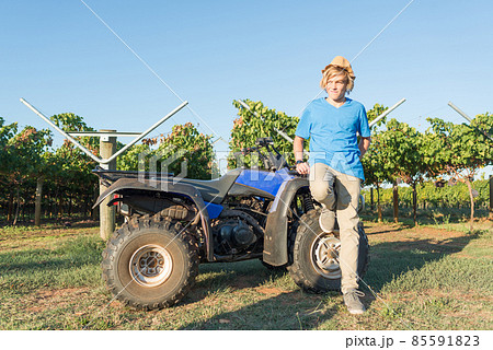 Young farmer standing near quad bike Young farmer standing near quad bike 85591823