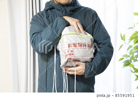 地震がきて緊急避難袋を抱えた男性 地震がきて緊急避難袋を抱えた男性 85591951