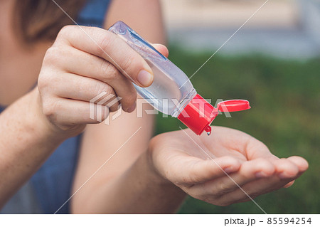 Women's hands using wash hand sanitizer gel pump dispenser 85594254