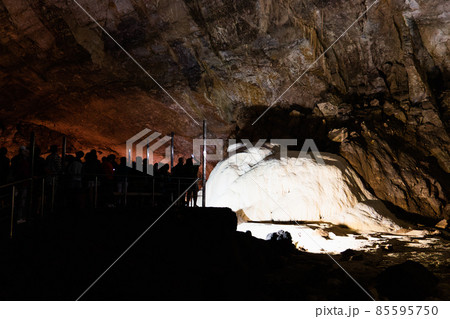 Silhouettes of tourists in cave Of New Athos in Abkhazia. Tourist place. Stoloktites and stologmites 85595750
