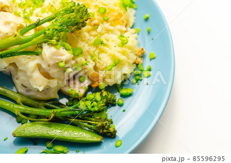 Tender pieces of smoked haddock and pollock in a creamy cheese sauce sat beneath buttery mash served with green vegetables Tender pieces of smoked haddock and pollock in a creamy cheese sauce sat beneath buttery mash served with green vegetables 85596295