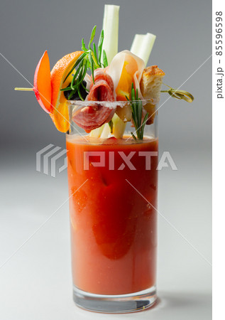 Bloody Mary with interesting decoration with a small snack on top of a cocktail glass 85596598