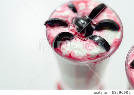 Drinks shots prepared by the bartender at the Halloween party decorated with black olives in the shape of spiders 85596609