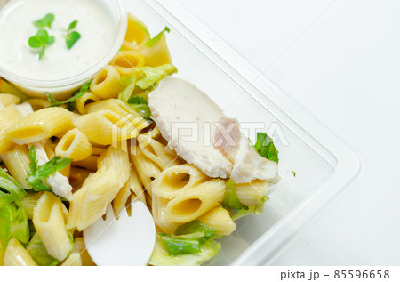 Penne pasta in a mayonnaise dressing with bacon pieces topped with parsley rubbed cooked chicken breast pieces Penne pasta in a mayonnaise dressing with bacon pieces topped with parsley rubbed cooked chicken breast pieces 85596658